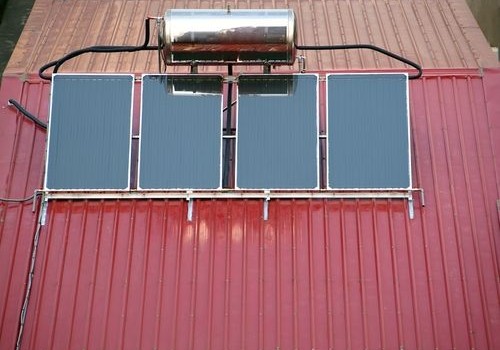 Solar water heating system mounted on a corrugated metal roof